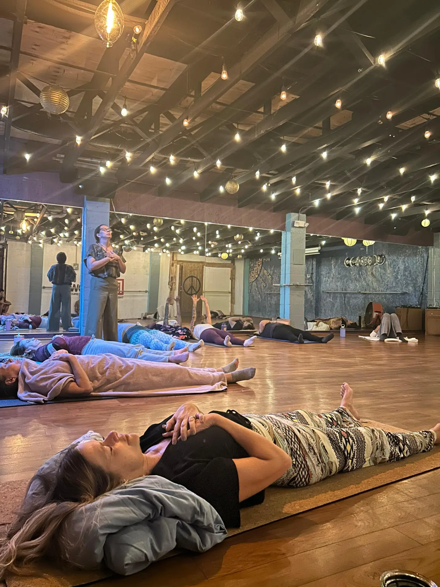 Group breathwork session in a studio with participants resting on mats